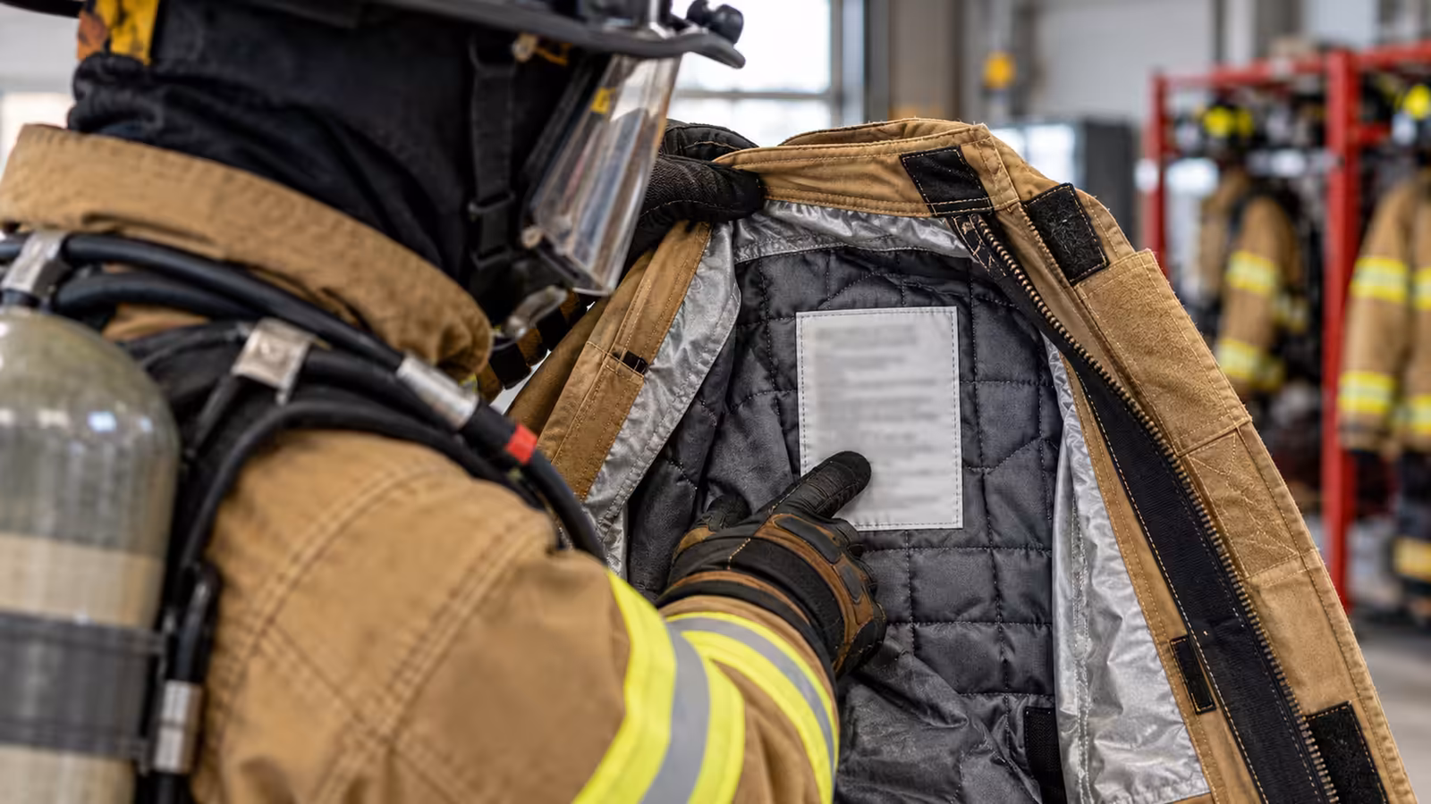 Etiqueta de certificación y cuidado cosida en el interior de un chaquetón estructural, con barrera de humedad y forro térmico visibles